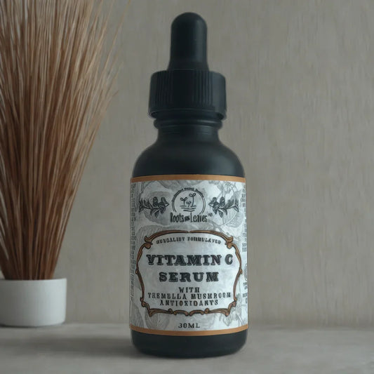 Vitamin C serum with tremella mushroom antioxidants in a black dropper bottle on a marble surface with decorative dried grass. Come see us at Awaken, Franklin, Tennessee