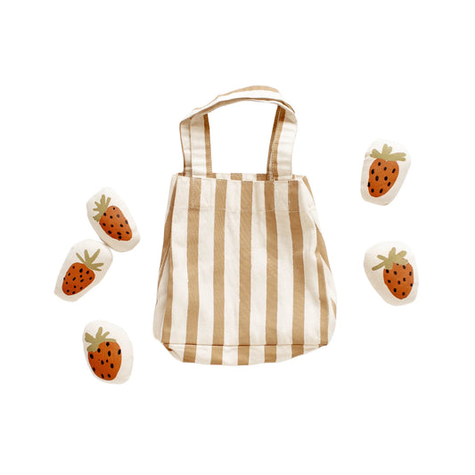 Beige and white striped tote bag with fabric strawberries around it. Come see us at Awaken, Franklin, Tennessee
