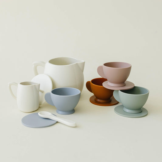 Minimalist ceramic tea set with cups, saucers, pitcher, and spoon in soft colors. Come see us at Awaken, Franklin, Tennessee