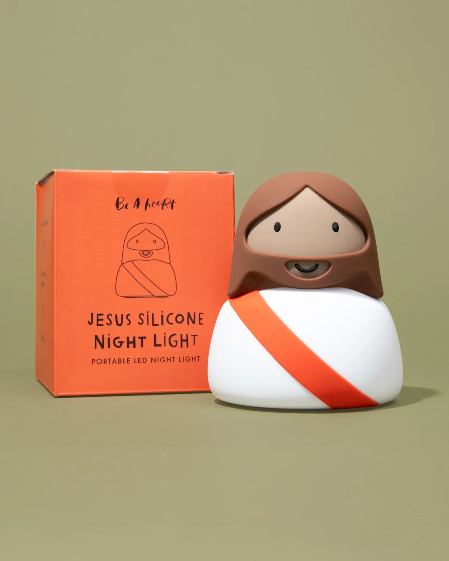 Jesus silicone night light with orange sash and packaging on neutral background. Come see us at Awaken, Franklin, Tennessee