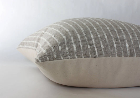Neutral striped decorative pillow with textured taupe and cream fabric on plain background. Come see us at Awaken, Franklin, Tennessee