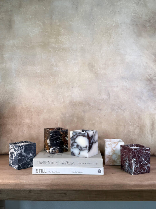 Marble cube candle holders on wooden shelf with natural light and neutral wall, come see us at Awaken, Franklin, Tennessee