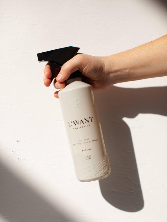 Hand holding L'AVANT Collective multipurpose cleaner bottle, Come see us at Awaken, Franklin, Tennessee