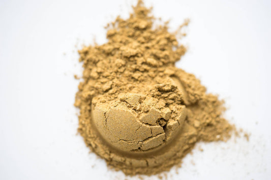 Close-up of cracked brown powder heap on white surface, natural herbal supplement Come see us at Awaken, Franklin, Tennessee