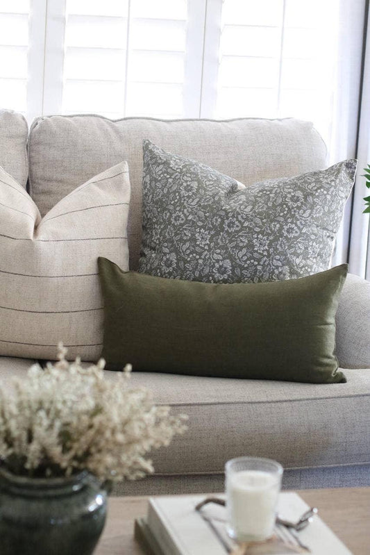 Neutral living room sofa with beige, patterned, and green decorative pillows, cozy decor. Come see us at Awaken, Franklin, Tennessee