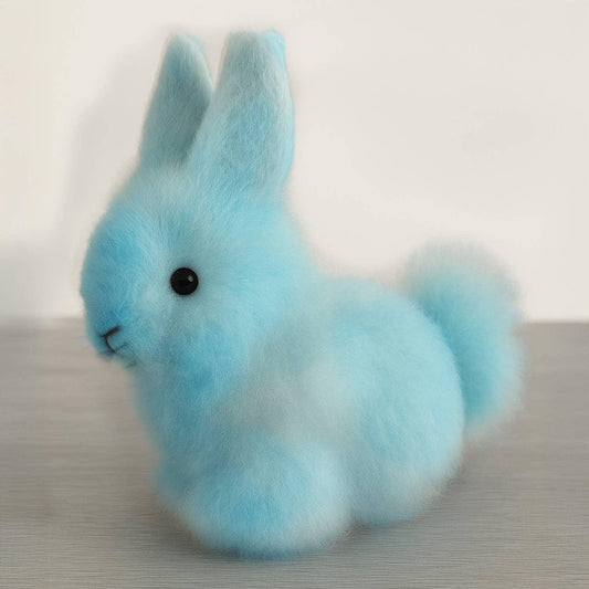 Soft blue faux fur bunny figurine with fluffy tail on wooden table, Come see us at Awaken, Franklin, Tennessee
