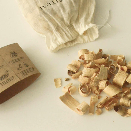 Wood shaving curls on white surface with natural fabric pouch and craft paper label. Come see us at Awaken, Franklin, Tennessee