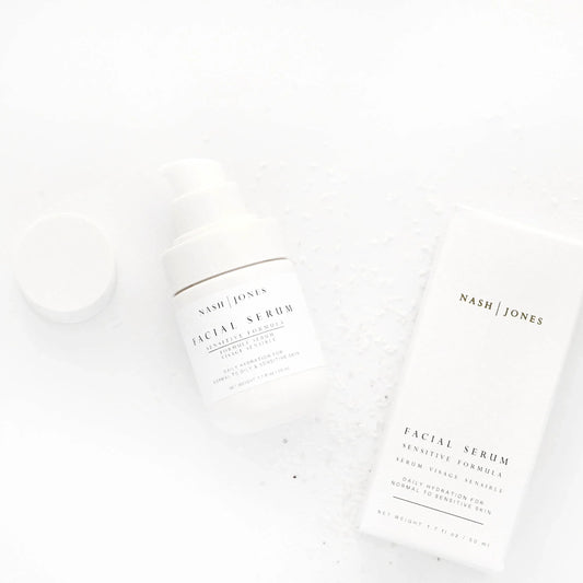Nash Jones facial serum bottle and box on white surface with salt crystals, skincare product. Come see us at Awaken, Franklin, Tennessee