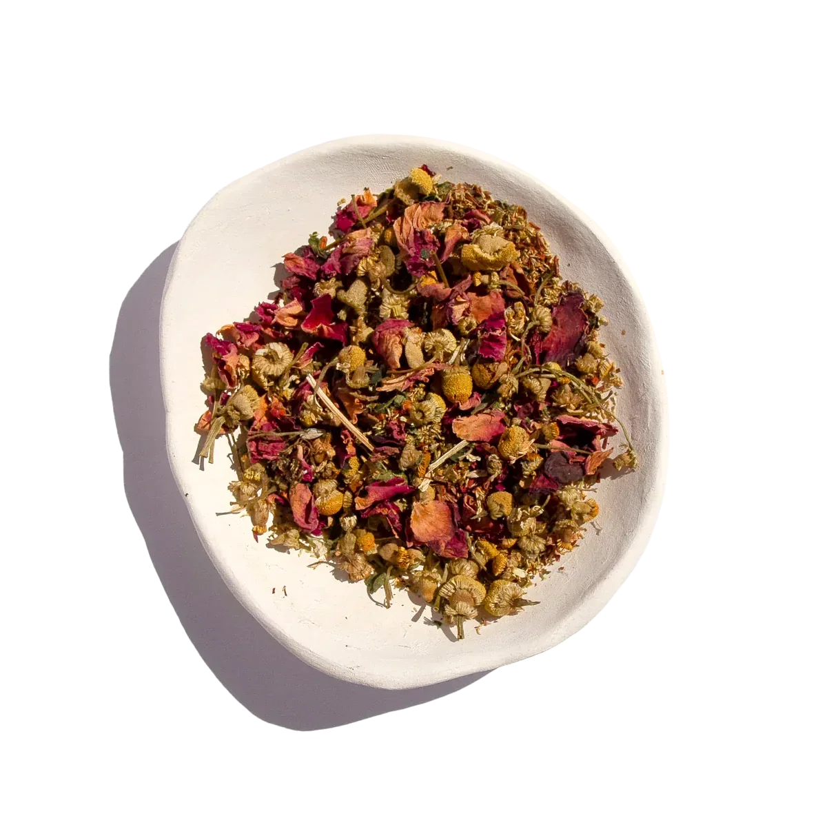 Herbal tea blend with chamomile and rose petals in white bowl. Come see us at Awaken, Franklin, Tennessee