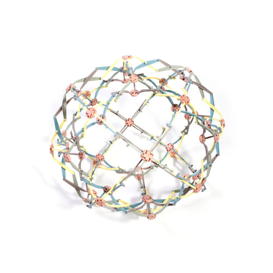Expandable colorful metal toy ball with yellow, blue, and gray segments on white background, Come see us at Awaken, Franklin, Tennessee