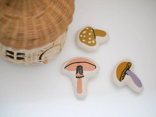 Three fabric mushroom toys near a woven basket on white surface, Come see us at Awaken, Franklin, Tennessee