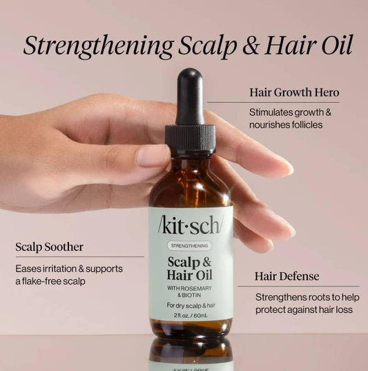 Hand holding bottle of kitsch Strengthening Scalp & Hair Oil with rosemary and biotin. Come see us at Awaken, Franklin, Tennessee