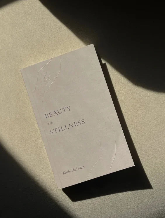 Book titled Beauty in the Stillness by Karin Haddad with soft light and shadow, Come see us at Awaken, Franklin, Tennessee