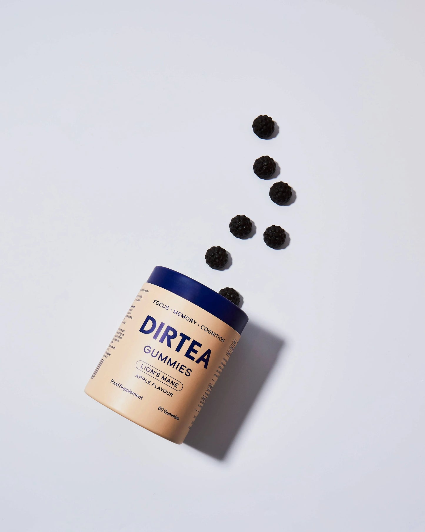 Dirtea Lion's Mane apple flavor gummies spilling from beige and blue bottle on white background. Come see us at Awaken, Franklin, Tennessee