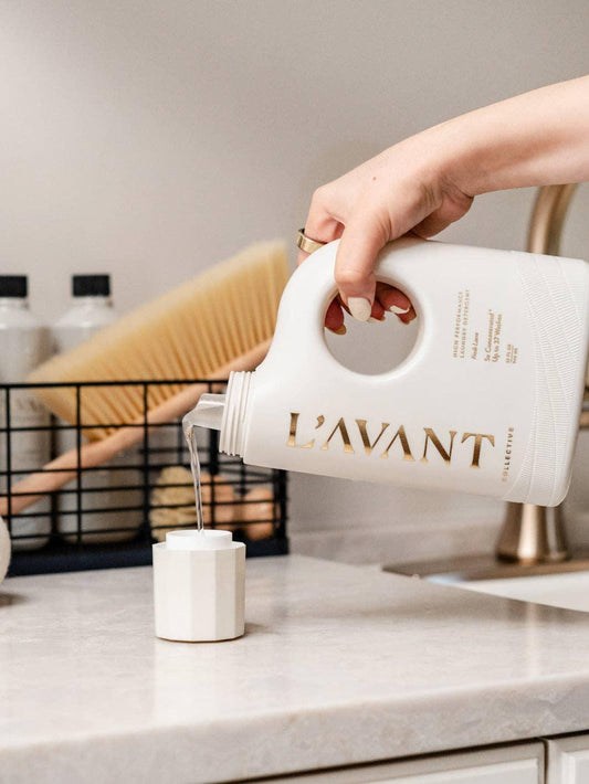 Hand pouring L'AVANT detergent in modern laundry room, Come see us at Awaken, Franklin, Tennessee