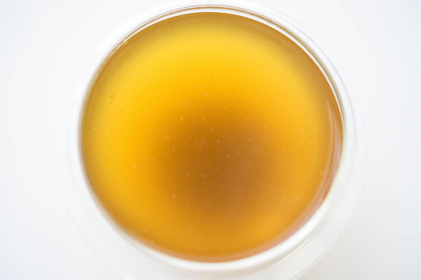 Close-up of a glass filled with golden liquid, likely tea or cider. Come see us at Awaken, Franklin, Tennessee