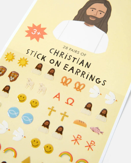 Sheet of 28 pairs of Christian stick-on earrings with symbols like crosses, doves, and rainbows. Come see us at Awaken, Franklin, Tennessee