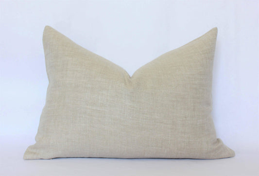 Beige linen pillow with textured fabric on white background. Come see us at Awaken, Franklin, Tennessee
