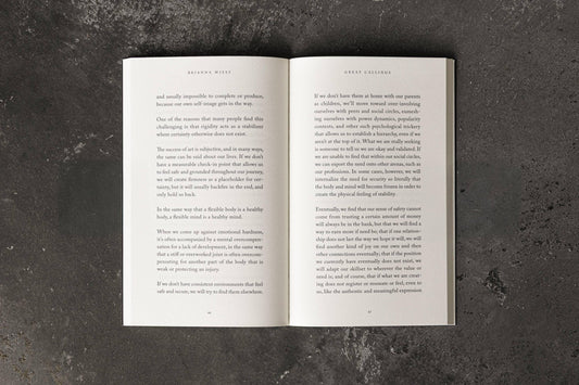 Open book on concrete surface showing text by Brianna Wiest titled Great Callings. Come see us at Awaken, Franklin, Tennessee