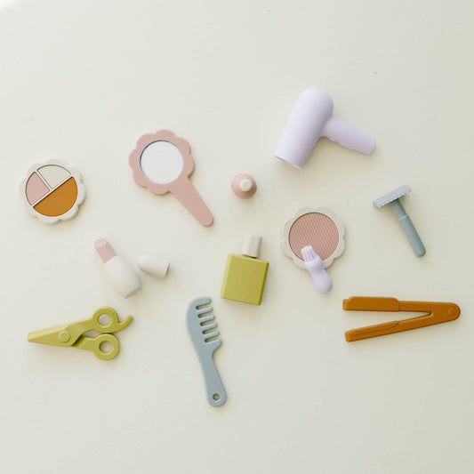 Pastel-colored toy beauty and hair styling set on white background with mirror, comb, and hairdryer. Come see us at Awaken, Franklin, Tennessee