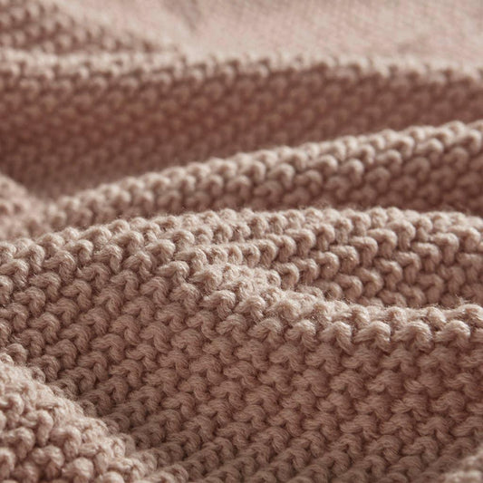 Close-up of soft pink knitted fabric texture, showcasing detailed stitches. Come see us at Awaken, Franklin, Tennessee