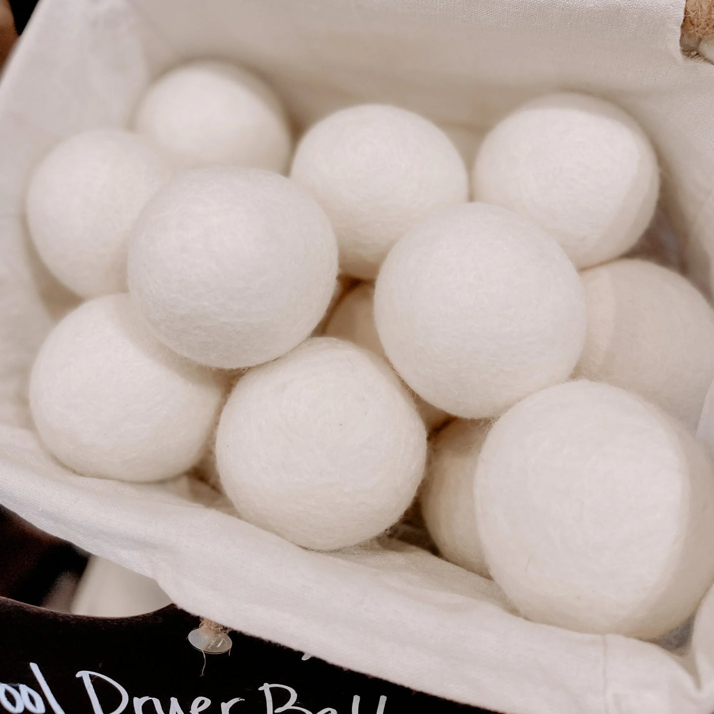 Natural wool dryer balls in a fabric basket, eco-friendly laundry products. Come see us at Awaken, Franklin, Tennessee