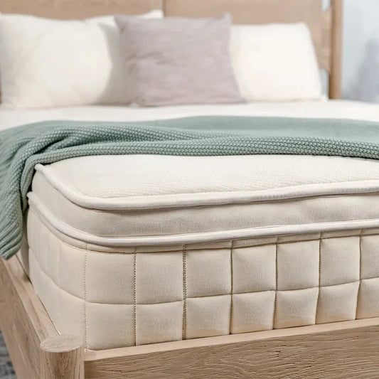 Luxury mattress with green knit blanket on wooden bed frame, Come see us at Awaken, Franklin, Tennessee