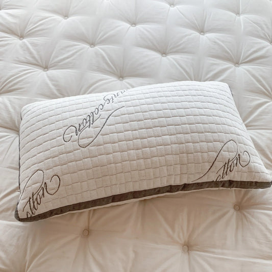 White textured pillow with stitched script on tufted white mattress Come see us at Awaken, Franklin, Tennessee