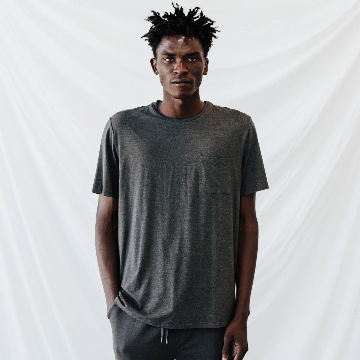Man wearing dark gray casual t-shirt and pants against white backdrop Come see us at Awaken, Franklin, Tennessee