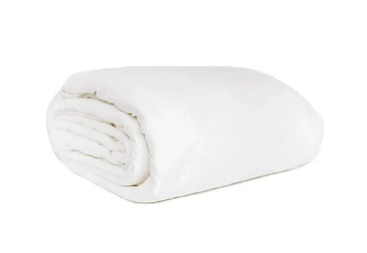 Folded white blanket on a white background for cozy home comfort. Come see us at Awaken, Franklin, Tennessee