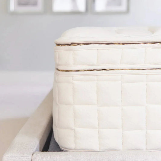 Close-up of a quilted white mattress with zipper detail, Come see us at Awaken, Franklin, Tennessee