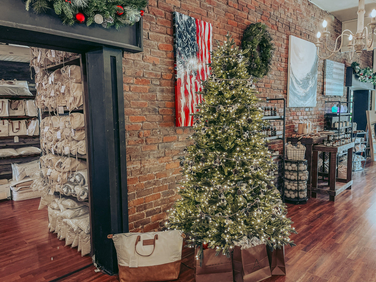 Christmas tree with lights in cozy brick store, gift bags, wall art, Come see us at Awaken, Franklin, Tennessee