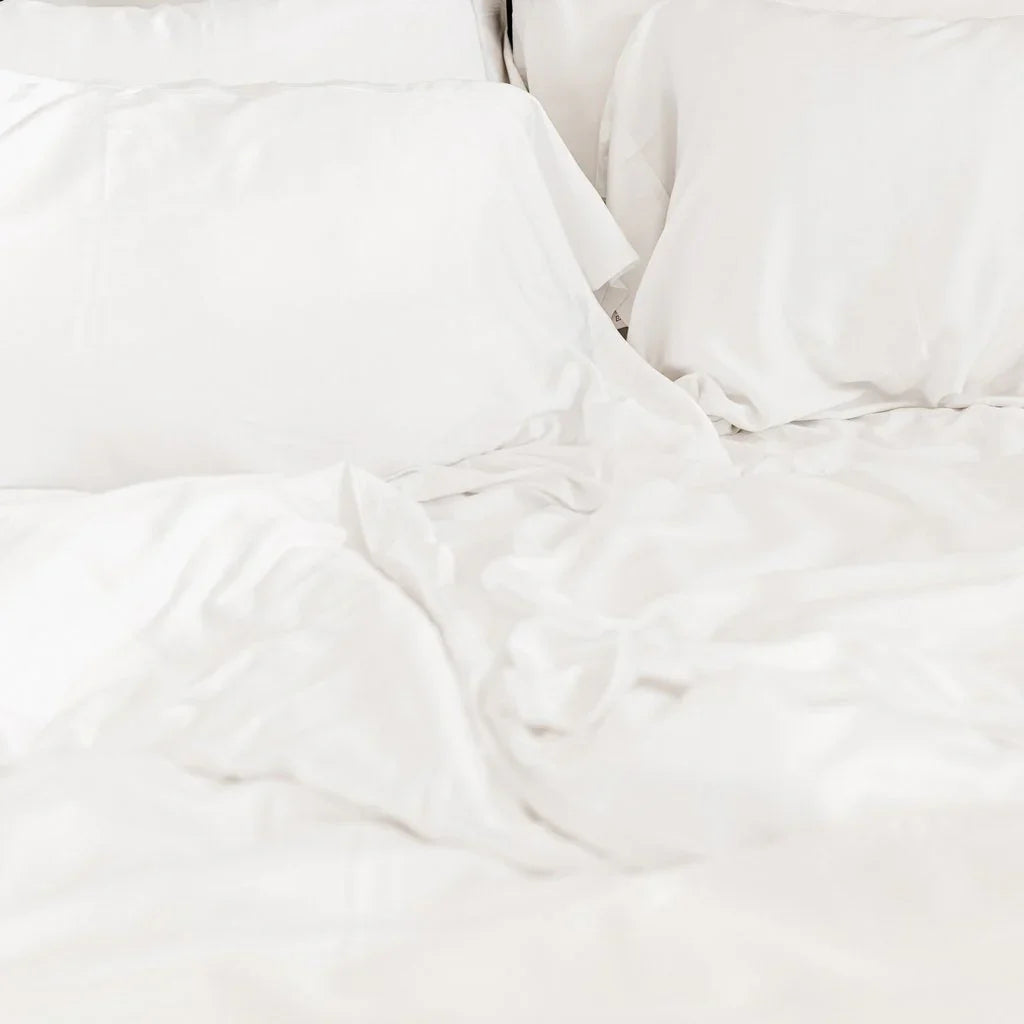 Soft white bed sheets and pillows on a bed. Come see us at Awaken, Franklin, Tennessee.