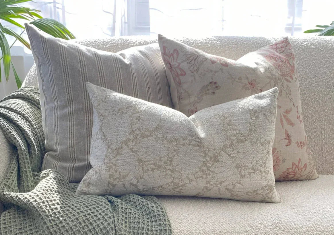 Neutral decorative pillows on a textured couch with cozy throw, Come see us at Awaken, Franklin, Tennessee