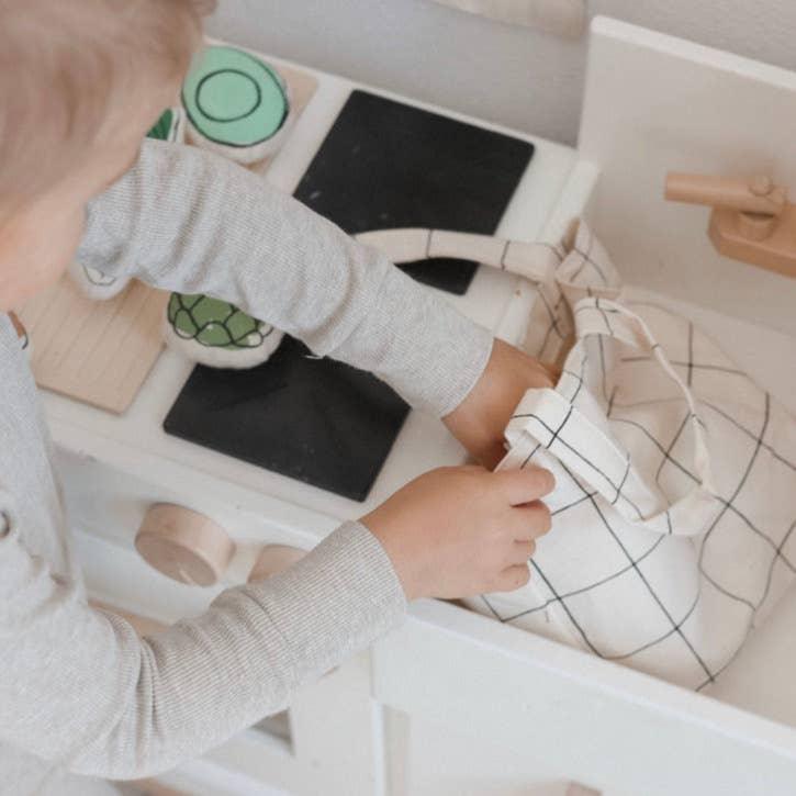 Child playing with toy kitchen and plush food, Come see us at Awaken, Franklin, Tennessee