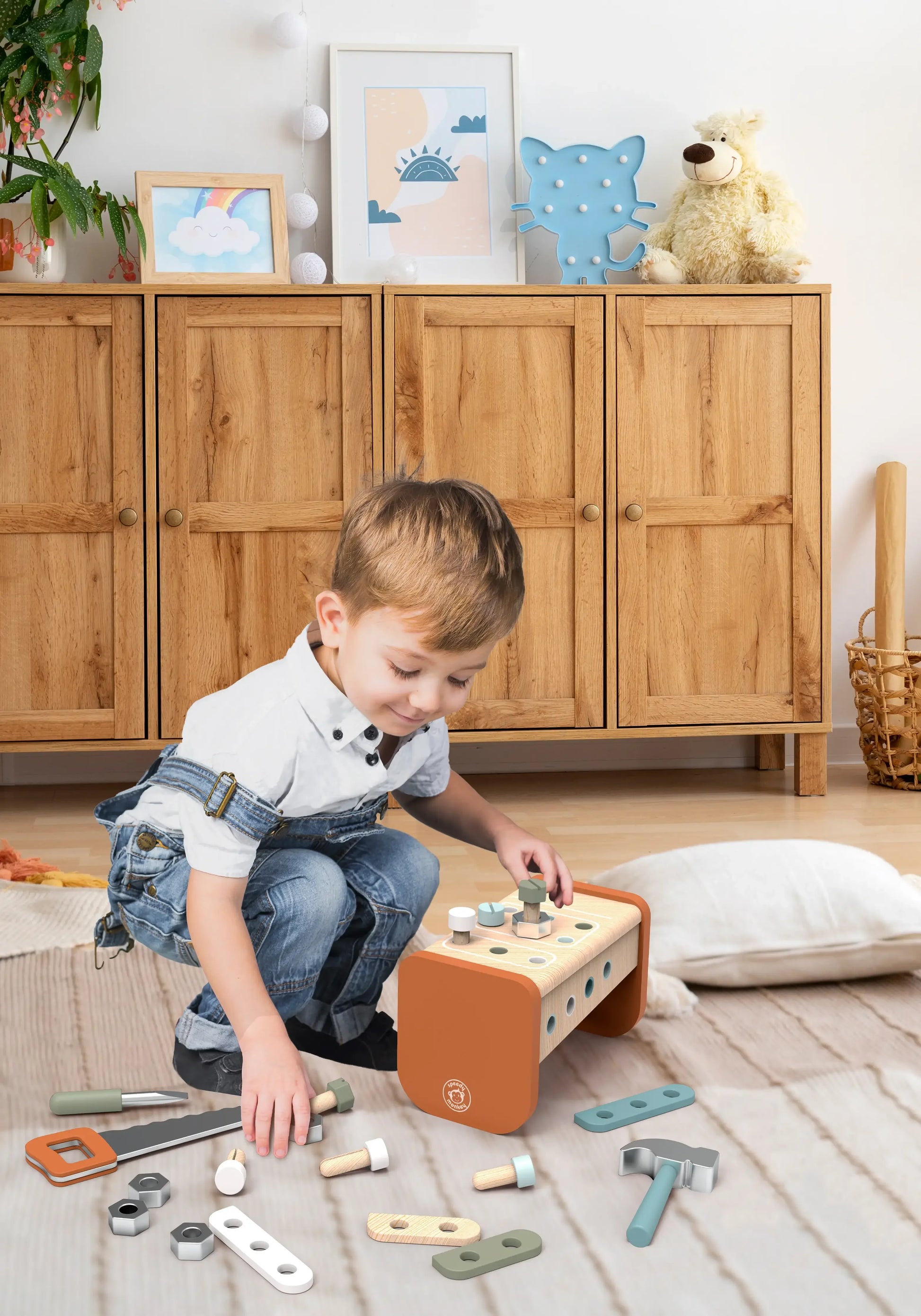 Child playing with wooden toy tools in cozy room with wooden cabinet and stuffed bear. Come see us at Awaken, Franklin, Tennessee