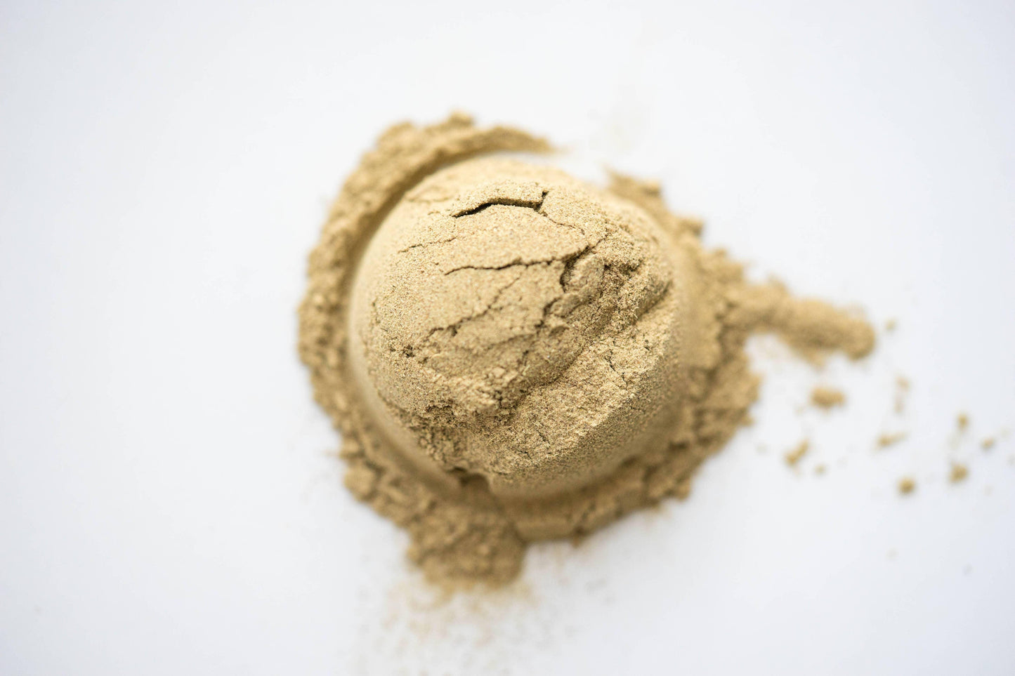 Pile of light brown powdered supplement on white background, Come see us at Awaken, Franklin, Tennessee