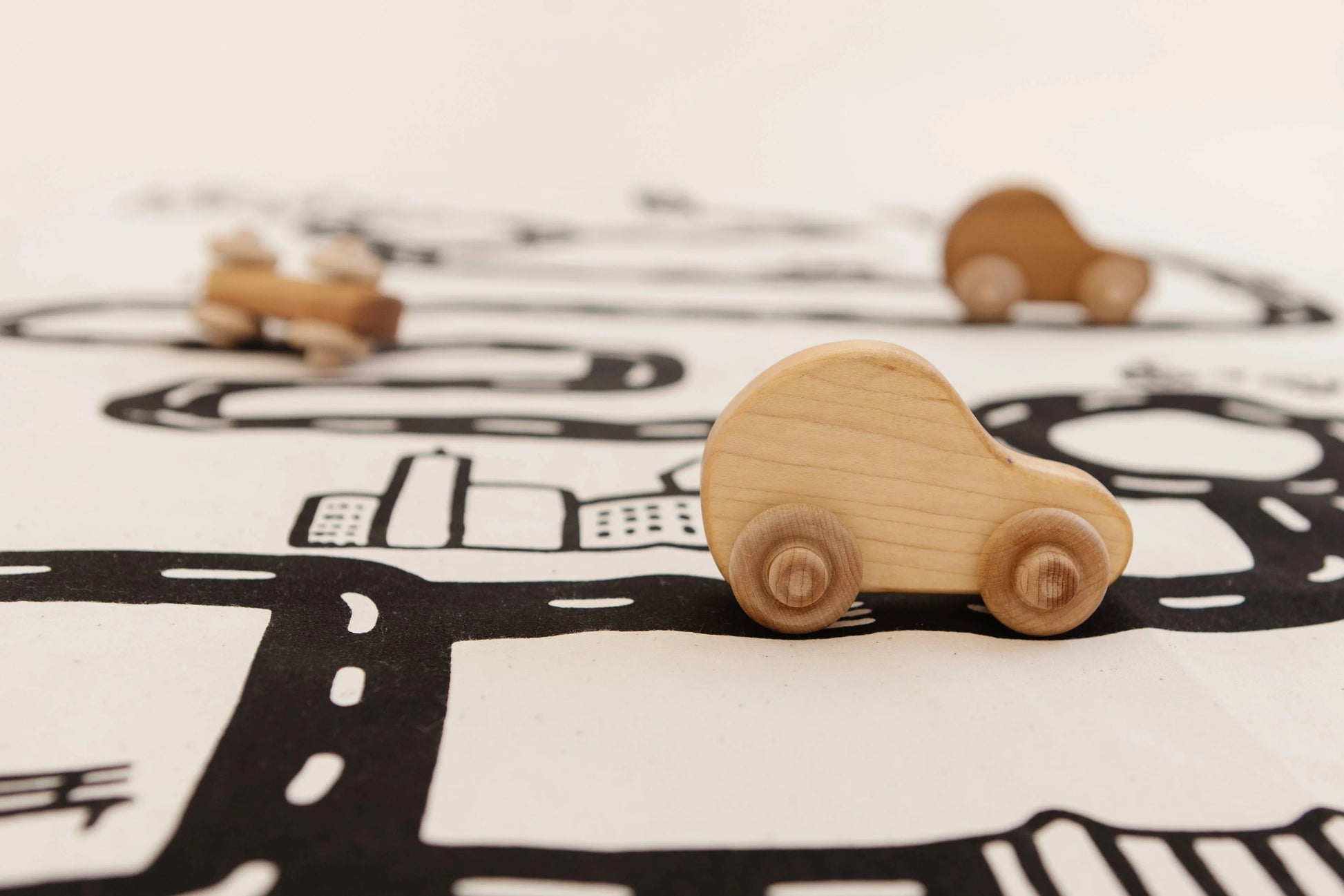 Wooden toy car on black and white play mat, Come see us at Awaken, Franklin, Tennessee