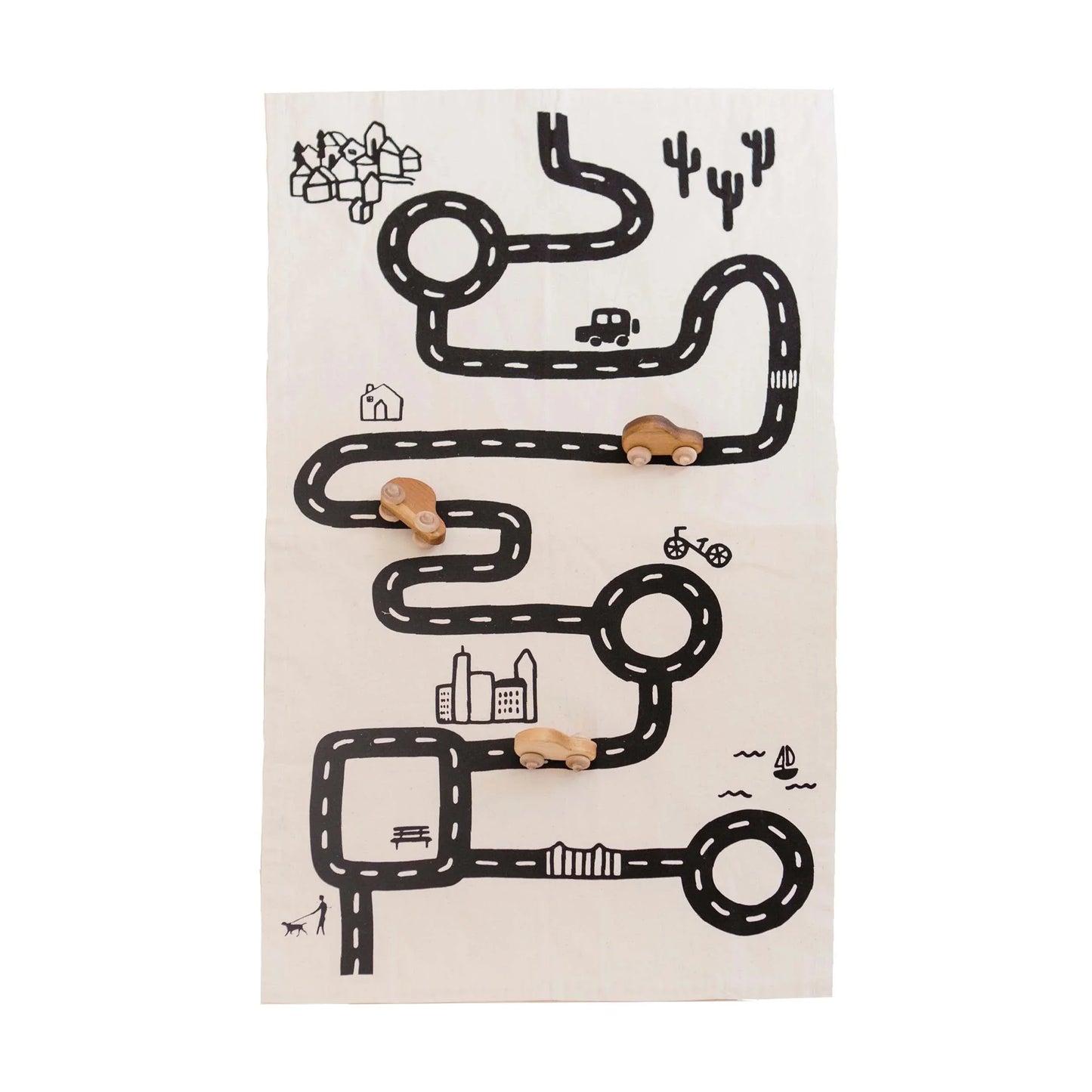 Kids wooden toy cars on a play mat road map with city, park, and cacti. Come see us at Awaken, Franklin, Tennessee