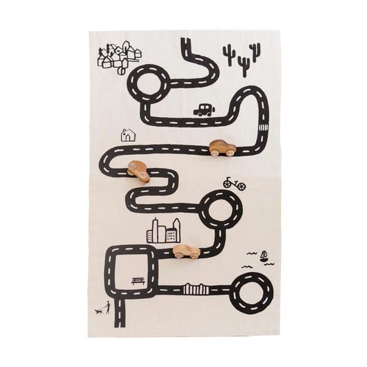 Kids wooden toy cars on a play mat road map with city, park, and cacti. Come see us at Awaken, Franklin, Tennessee