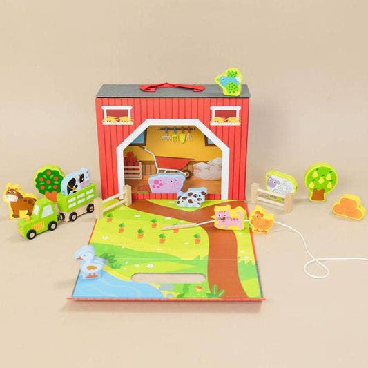 Wooden farm playset with barn, animals, tractor, and greenery. Come see us at Awaken, Franklin, Tennessee
