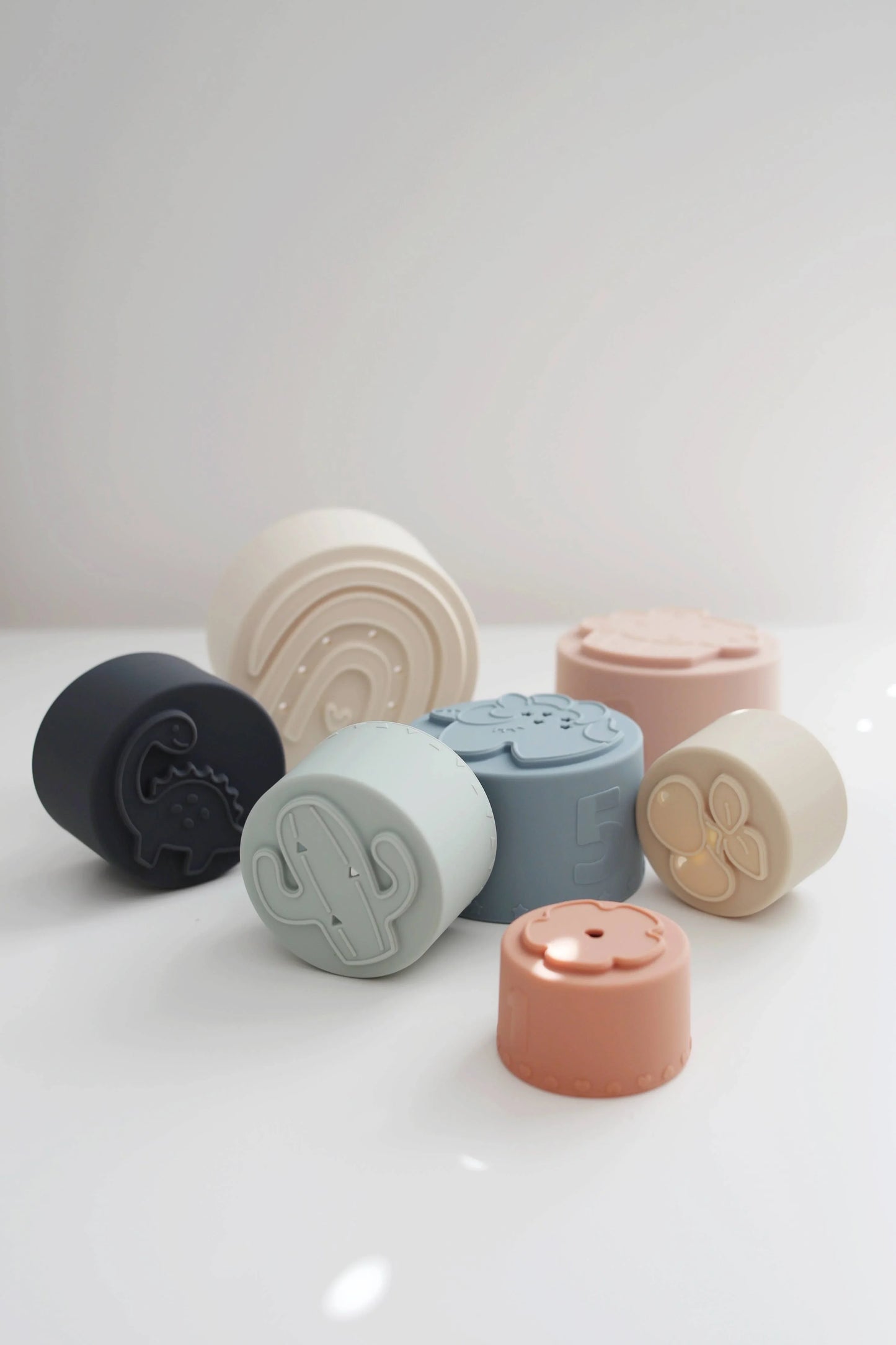 Pastel-colored silicone stacking cups with shapes and numbers on white surface. Come see us at Awaken, Franklin, Tennessee