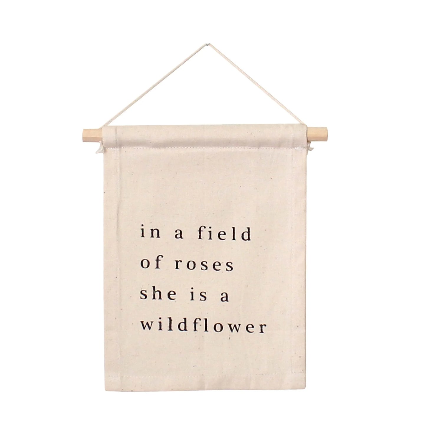 Canvas wall hanging with 'in a field of roses she is a wildflower' text, Come see us at Awaken, Franklin, Tennessee.