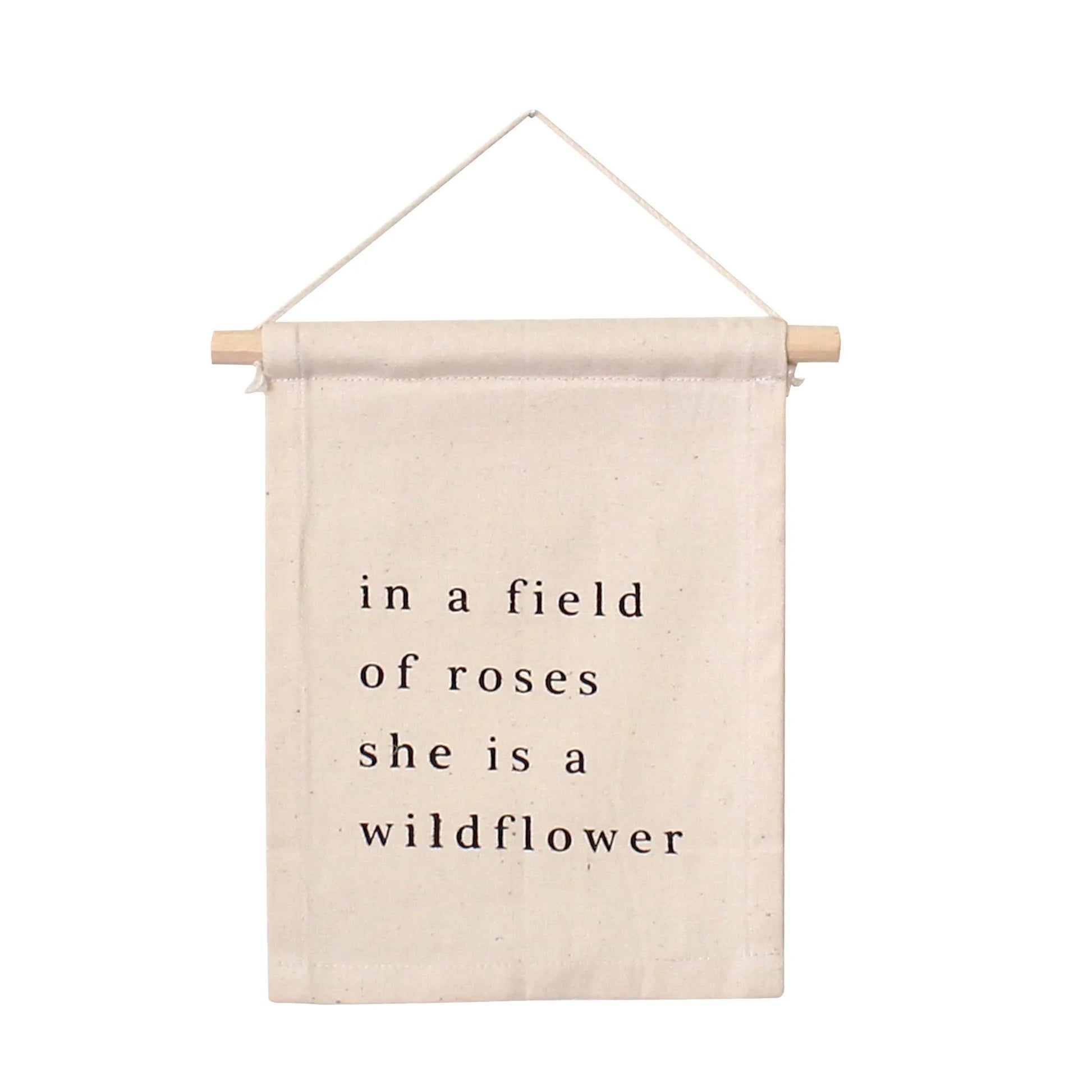 Canvas wall hanging with 'in a field of roses she is a wildflower' text, Come see us at Awaken, Franklin, Tennessee.