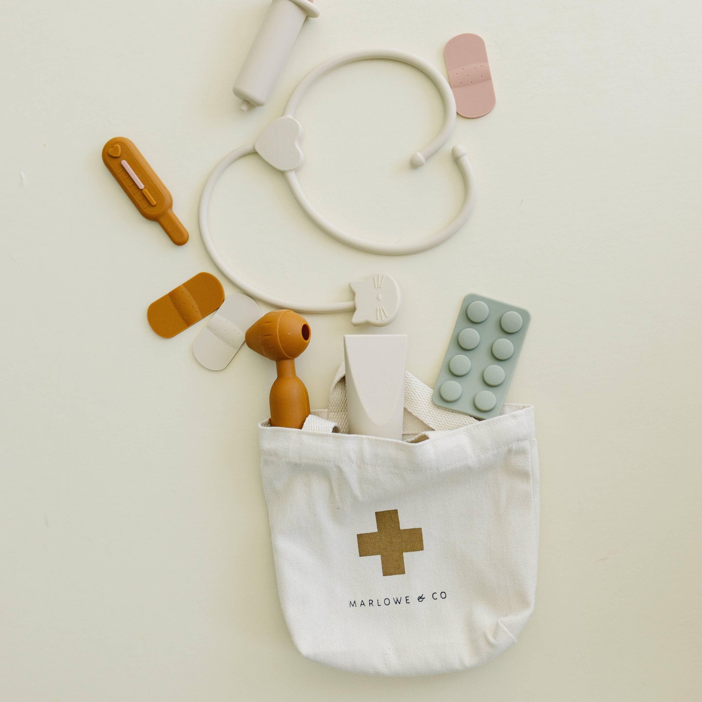 White canvas first aid bag with medical toys and bandages on light background. Come see us at Awaken, Franklin, Tennessee