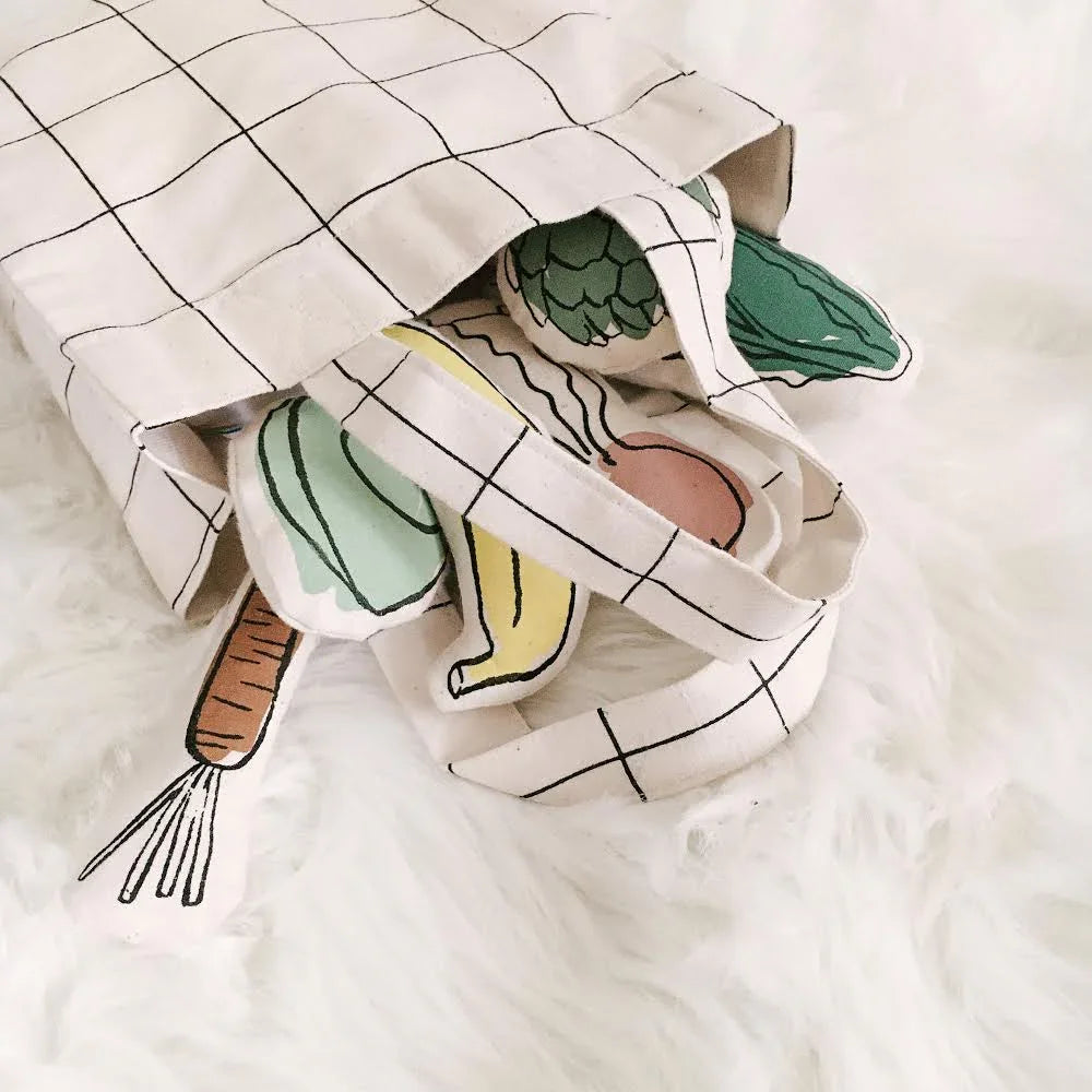 Grid tote bag with plush vegetables on white fur. Come see us at Awaken, Franklin, Tennessee.