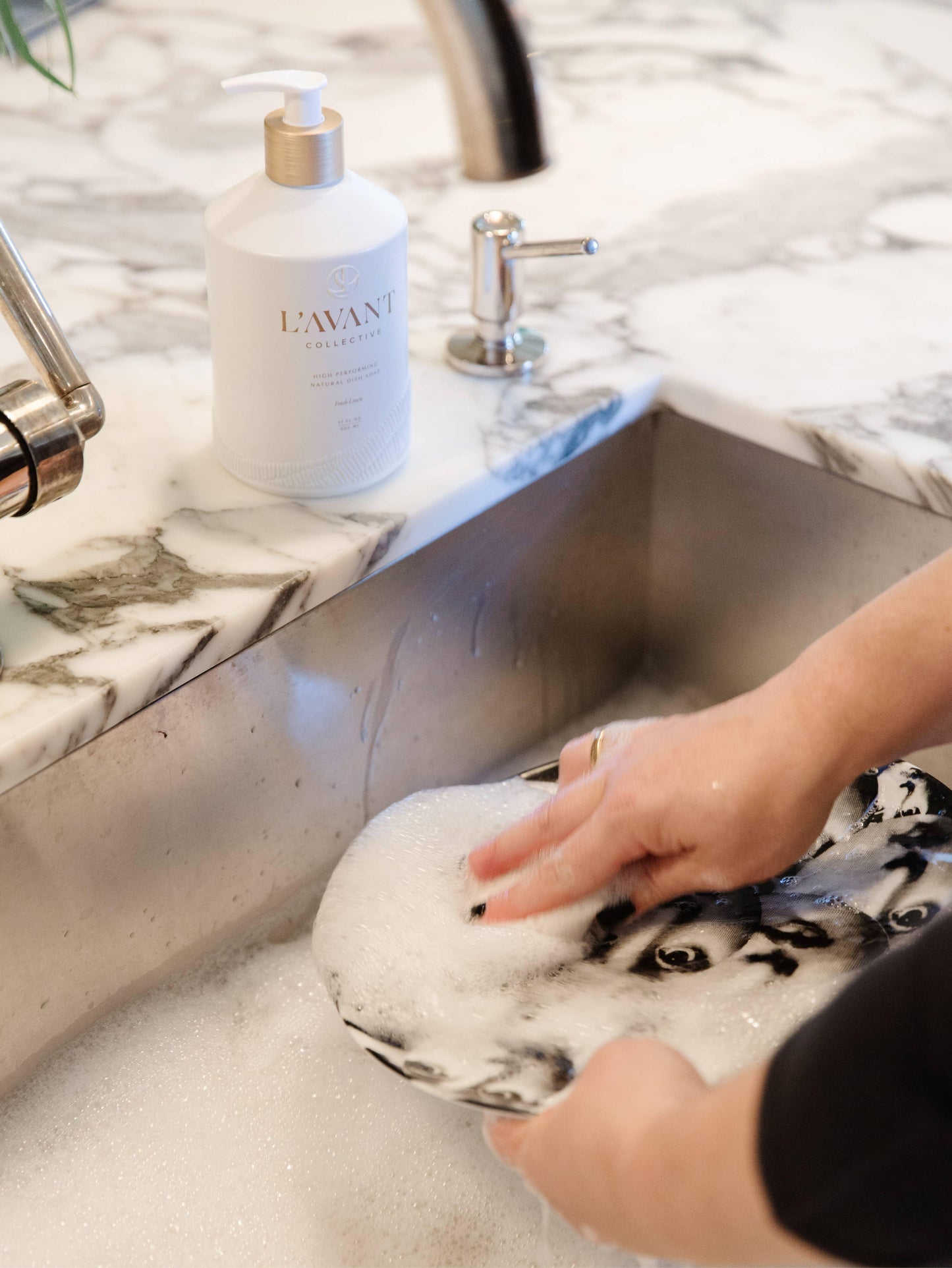 Hand washing dishes with L'AVANT Collective soap at marble sink, Come see us at Awaken, Franklin, Tennessee