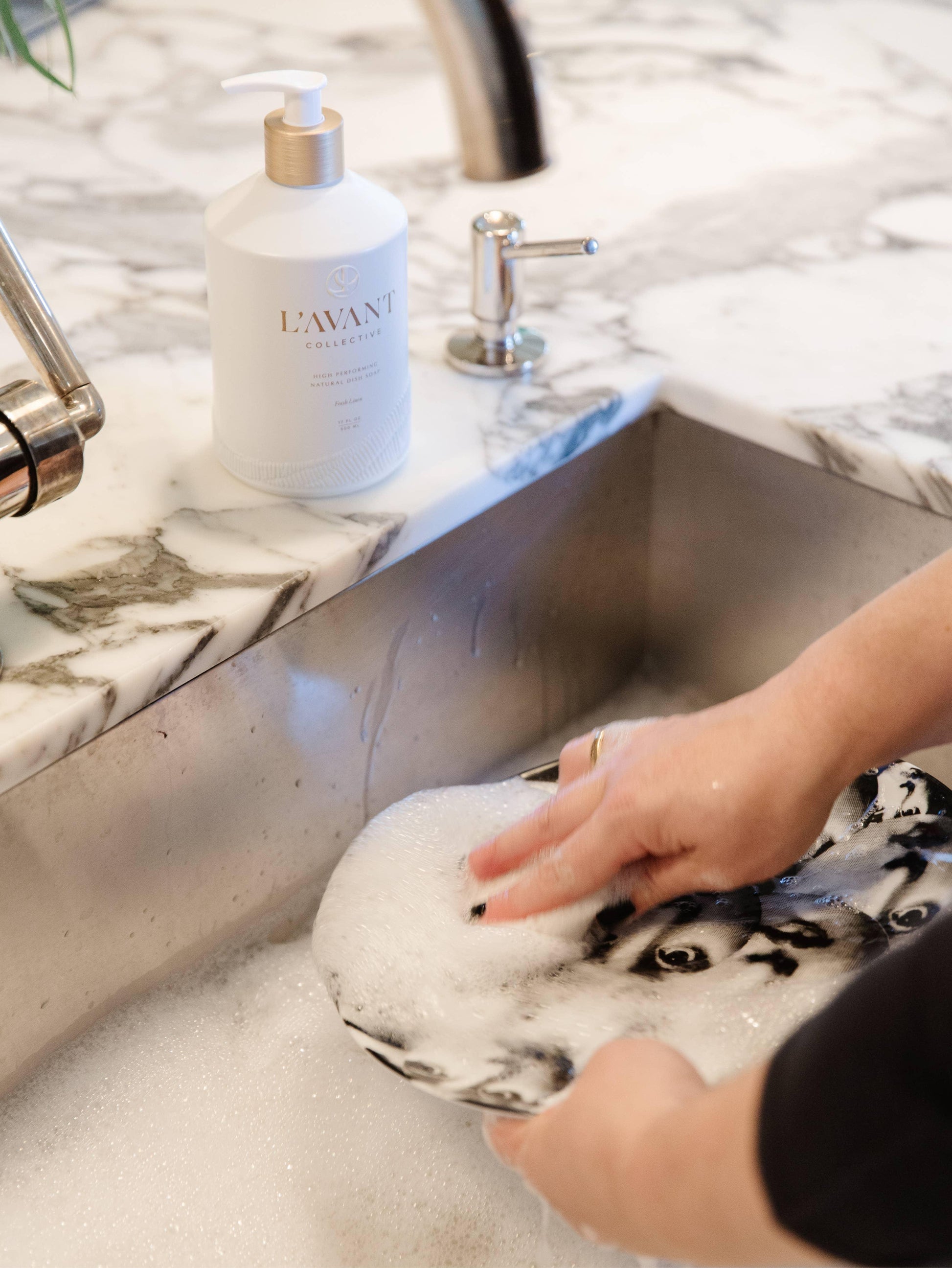 Hand washing dishes with L'AVANT Collective soap at marble sink, Come see us at Awaken, Franklin, Tennessee