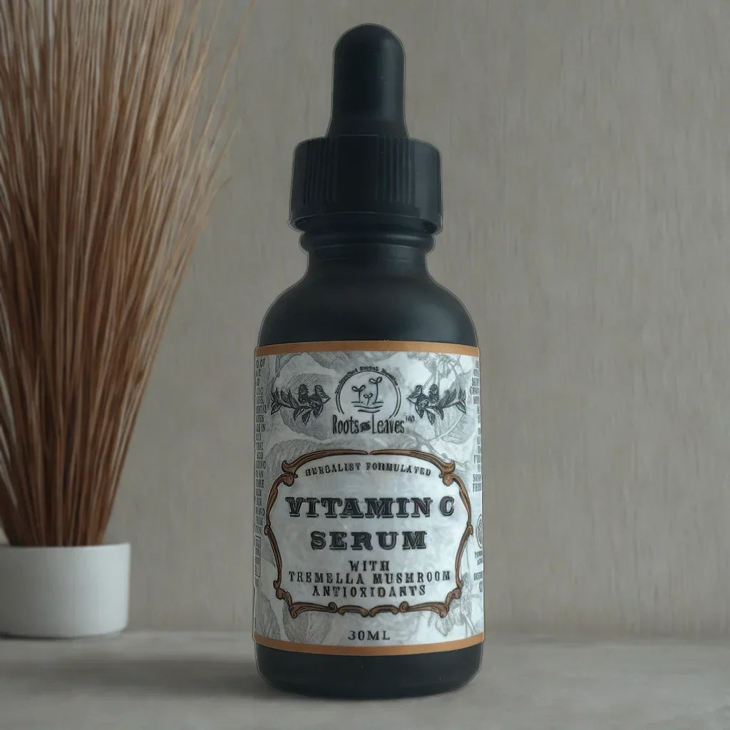 Vitamin C serum with tremella mushroom antioxidants in a black dropper bottle on a marble surface with decorative dried grass. Come see us at Awaken, Franklin, Tennessee