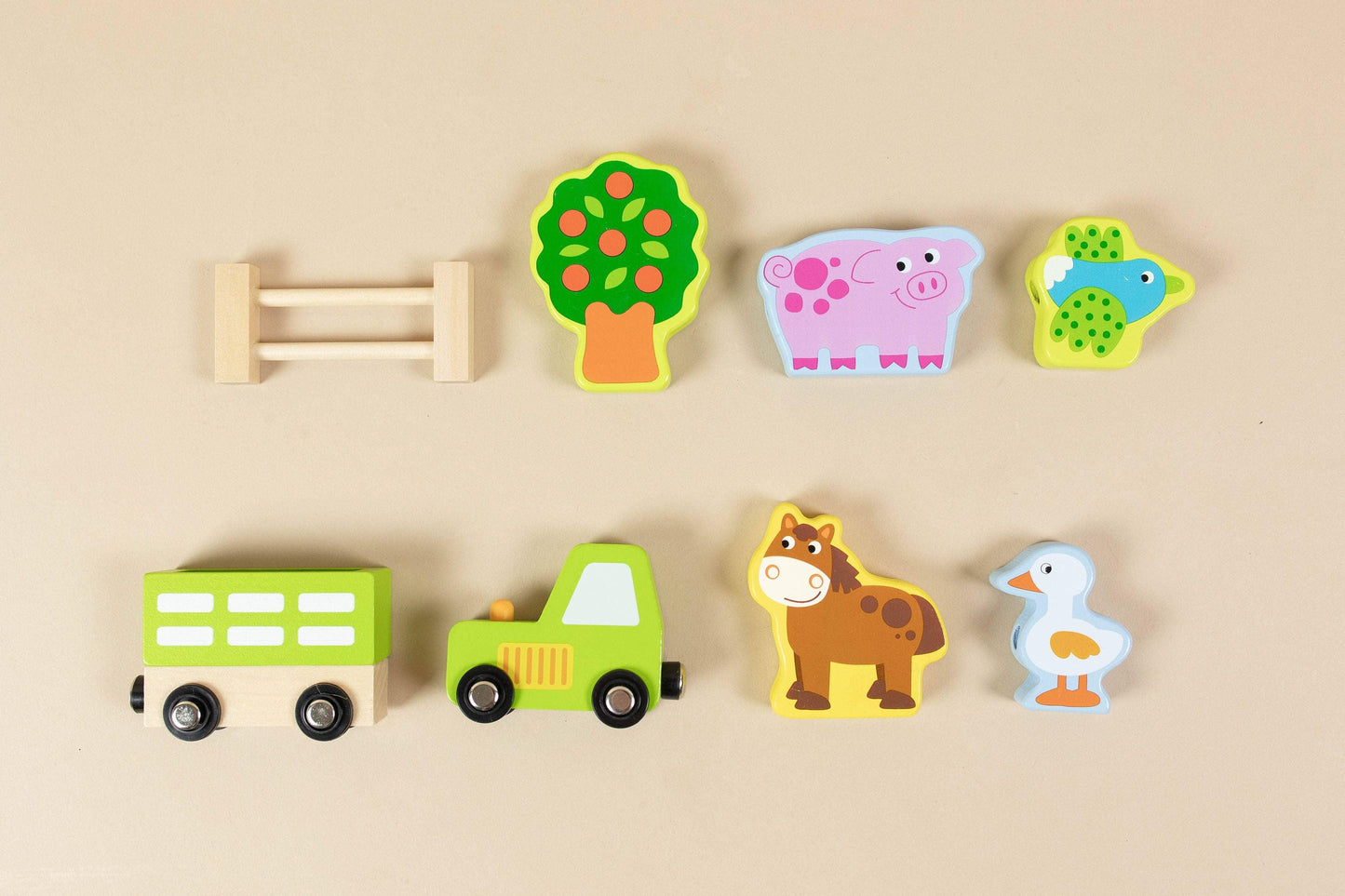 Colorful wooden farm animal toys and tree on beige background, Come see us at Awaken, Franklin, Tennessee